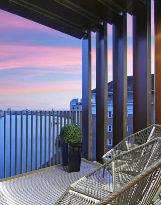 a hanging chair on a balcony with a view of the city