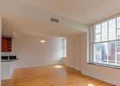 Thumbnail 74 of 74 - A large empty room with wooden floors and a window overlooking a cityscape.
