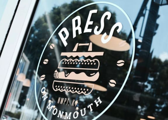 A window with a sticker that says  at Monmouth Row Apartments, Newport, KY