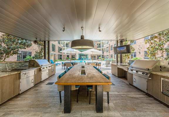 a large kitchen with stainless steel appliances and a wooden table