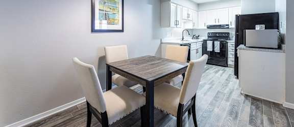 A dining room with a table and chairs.