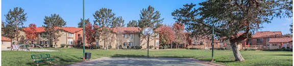 a parking lot with trees and buildings in the background at Riverview Springs, Oceanside, California