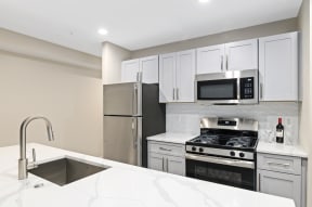 a kitchen with white cabinets and stainless steel appliances
