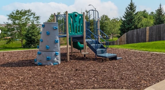 a playground with a rock climbing wall and slides