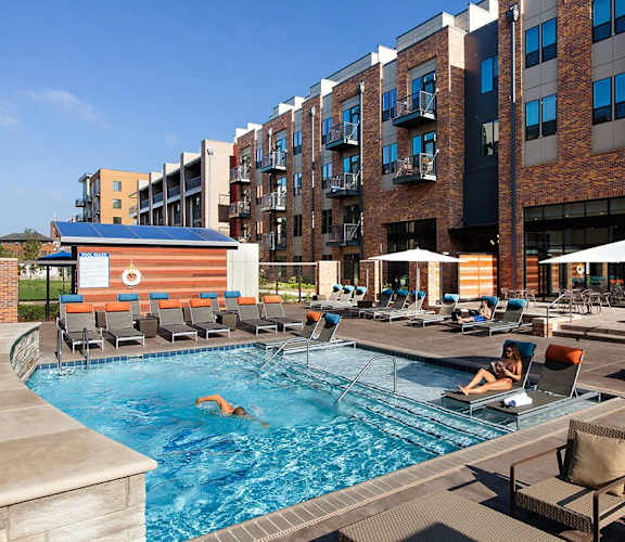 Outdoor Pool with Lounge Chairs and Umbrellas at CityWay Apartments in Indianapolis, IN