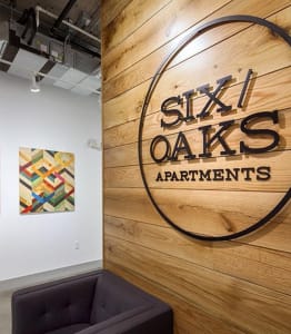a wall with a logo of six oaks apartments on it
