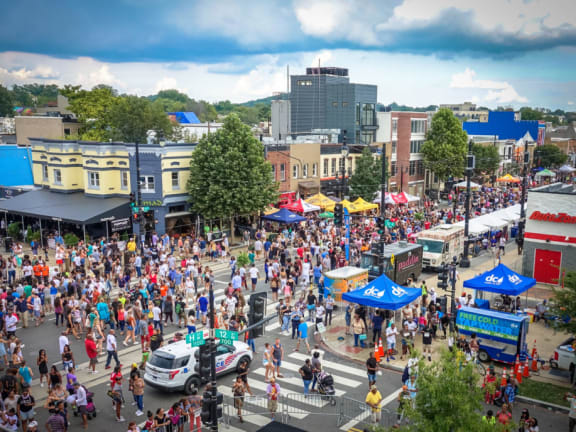 a crowd of people at a street festival in a city