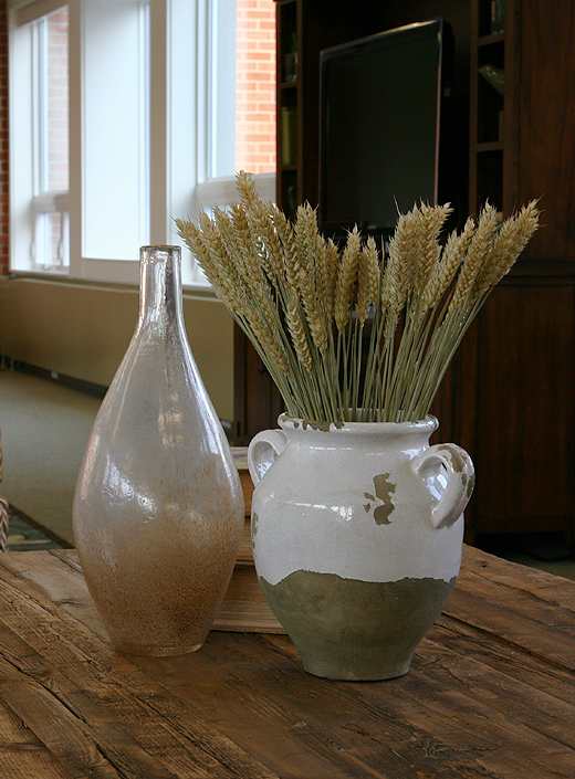 A dining table with blue bowls, plates and vases.