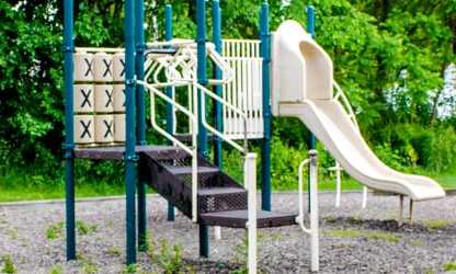 A playground with a slide and a climbing frame.