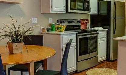 A kitchen with a table and chairs. at Commons at Dawson Creek Apartments, Oregon