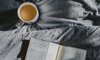 Coffee and book on bed