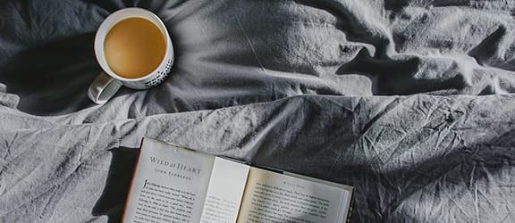 Coffee and book on bed