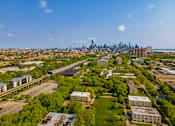 Thumbnail 50 of 59 - A cityscape with a mix of greenery and buildings under a clear sky.