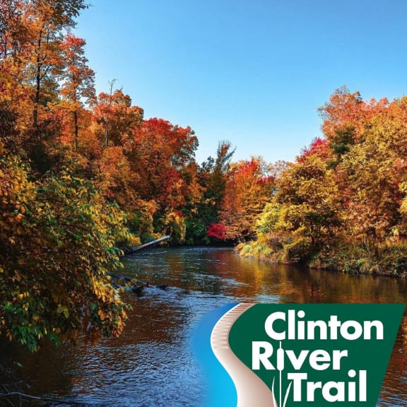 a river with trees in the background and a sign that reads trail