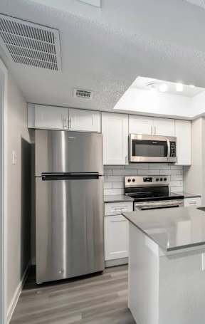 A modern kitchen with stainless steel appliances and a central island.