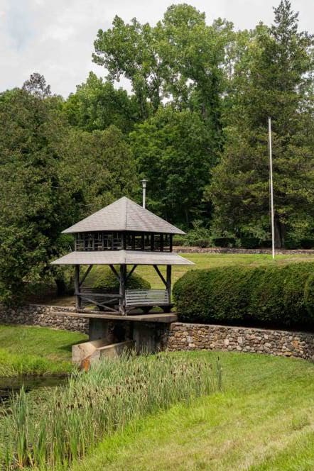 a gazebo and a pavilion in a park next to a river