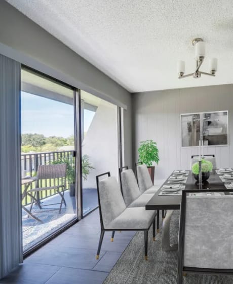 a dining room with a long dining table and a sliding glass door leading to a balcony at Piper Village West, Florida