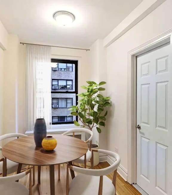 A dining room with a round table and chairs.at Sutton Collection, New York, NY 10022