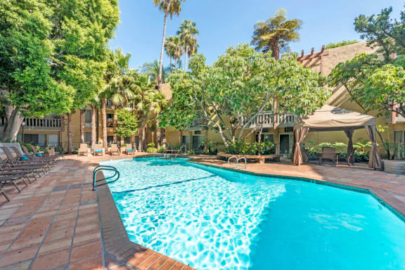 a large swimming pool in front of a house with a resort style pool