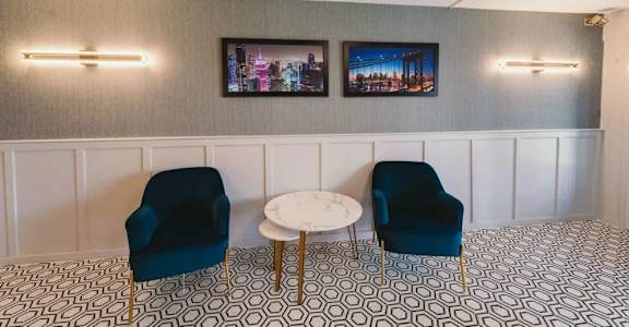 a living room with blue chairs and a white table at Five High, Connecticut, 06119