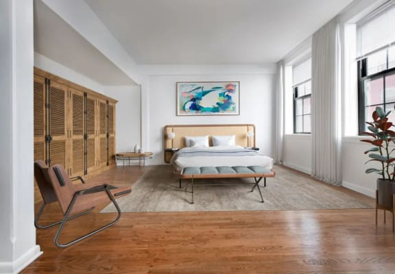 a bedroom with hardwood floors and white walls at Grand Adams Apartment Owner LLC, Hoboken, NJ