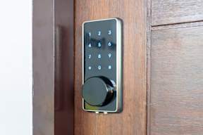 A keypad with numbers 1 to 10 is mounted on a wooden door.