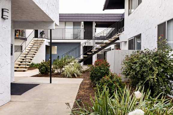 A white building with a staircase leading to a balcony.