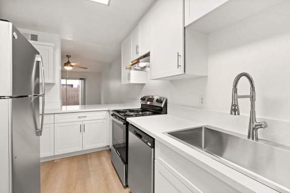 A modern kitchen with stainless steel appliances and white cabinets.