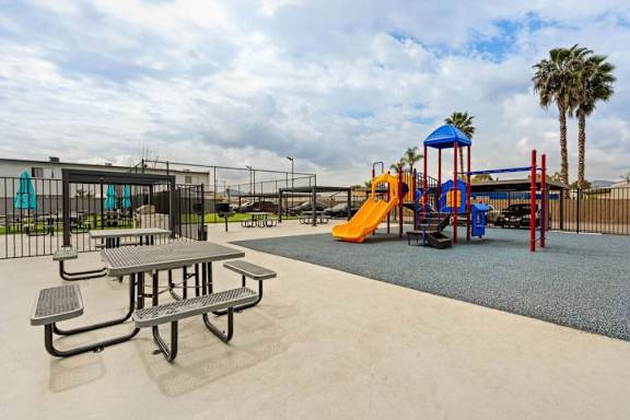A playground with a slide, swings, and a picnic table.