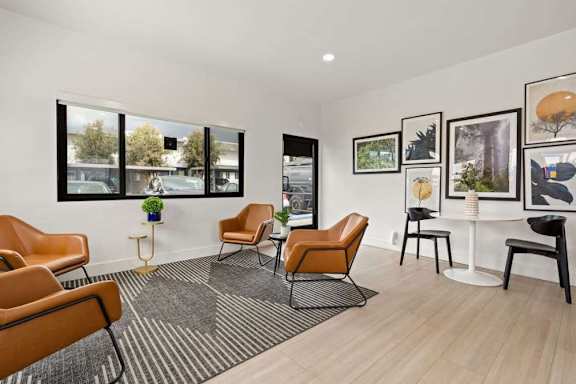 A room with a table, chairs and pictures on the wall.