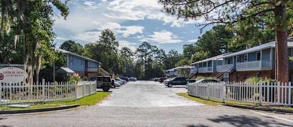 a street with houses on both sides and a white fence in the middle of the road