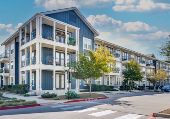 an empty street with an apartment building in the background