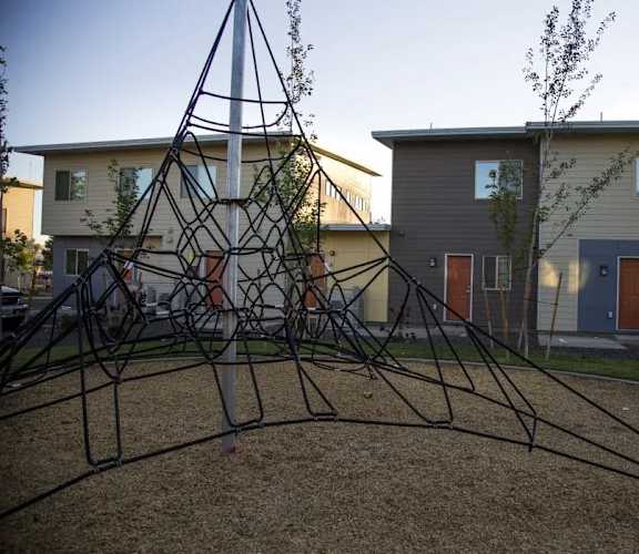 a swing set in a playground in front of a house