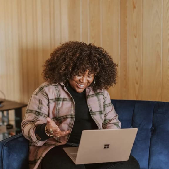 a woman sitting on a couch with a laptop