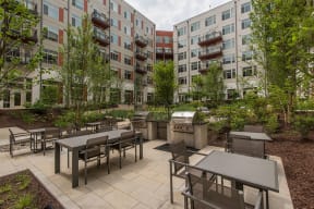 Outdoor patio with tables and chairs and a grill at Highgate at the Mile in McLean, VA