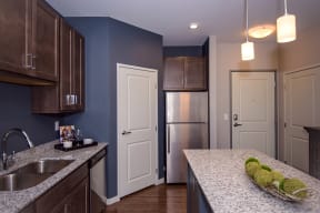 Spacious Kitchen with Dark Wood Cabinetry, Granite Countertops and Stainless Steel Appliances