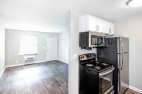 Condos at Villager Kitchen with Black/Stainless Steel Appliances, Wood Cabinets, and Access to Living Room