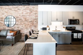 Maple Street Lofts Modern Kitchen with Open Layout, Hardwood Floors, Subway Tile Backsplash, and Breakfast Bar Counter