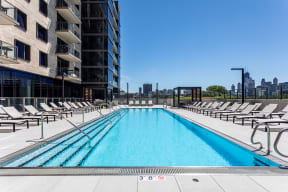 Sparkling Swimming Pool with Surrounding Chaise Lounge Chairs and Views of the City at North+Vine in Chicago, IL