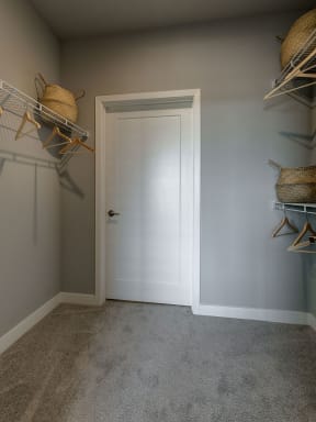 a walk in closet with gray walls and a white door