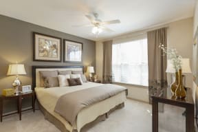 The Grove at Waterford Crossing Apartments in Hendersonville - Bedroom with Stylish Decor, Wall to Wall Carpet, Green and White and Grey Walls, Ceiling Fan, and Access to Bathroom