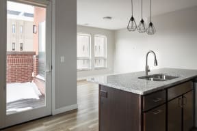 a kitchen with a sink and a doorway to a balcony