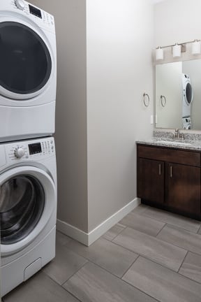a bathroom with a washer and dryer and a sink