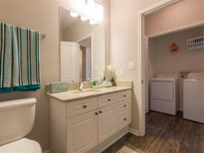 model bathroom and laundry room with washer and dryer included