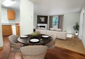 Open layout dining room between kitchen and living room. Contains round dining table and 4 chairs. Living room in background contains large sofa, window and corner fireplace.