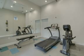 a gym with two treadmills and two elliptical machines