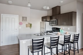Apartments for Rent in Corvallis, OR - The Quad - OSU Kitchen with stainless steel appliances and modern wood cabinets