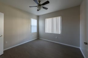 an empty bedroom with a ceiling fan