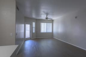 an empty living room with a ceiling fan