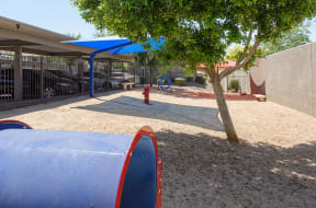 a playground with a blue tarp and a red fire hydrant